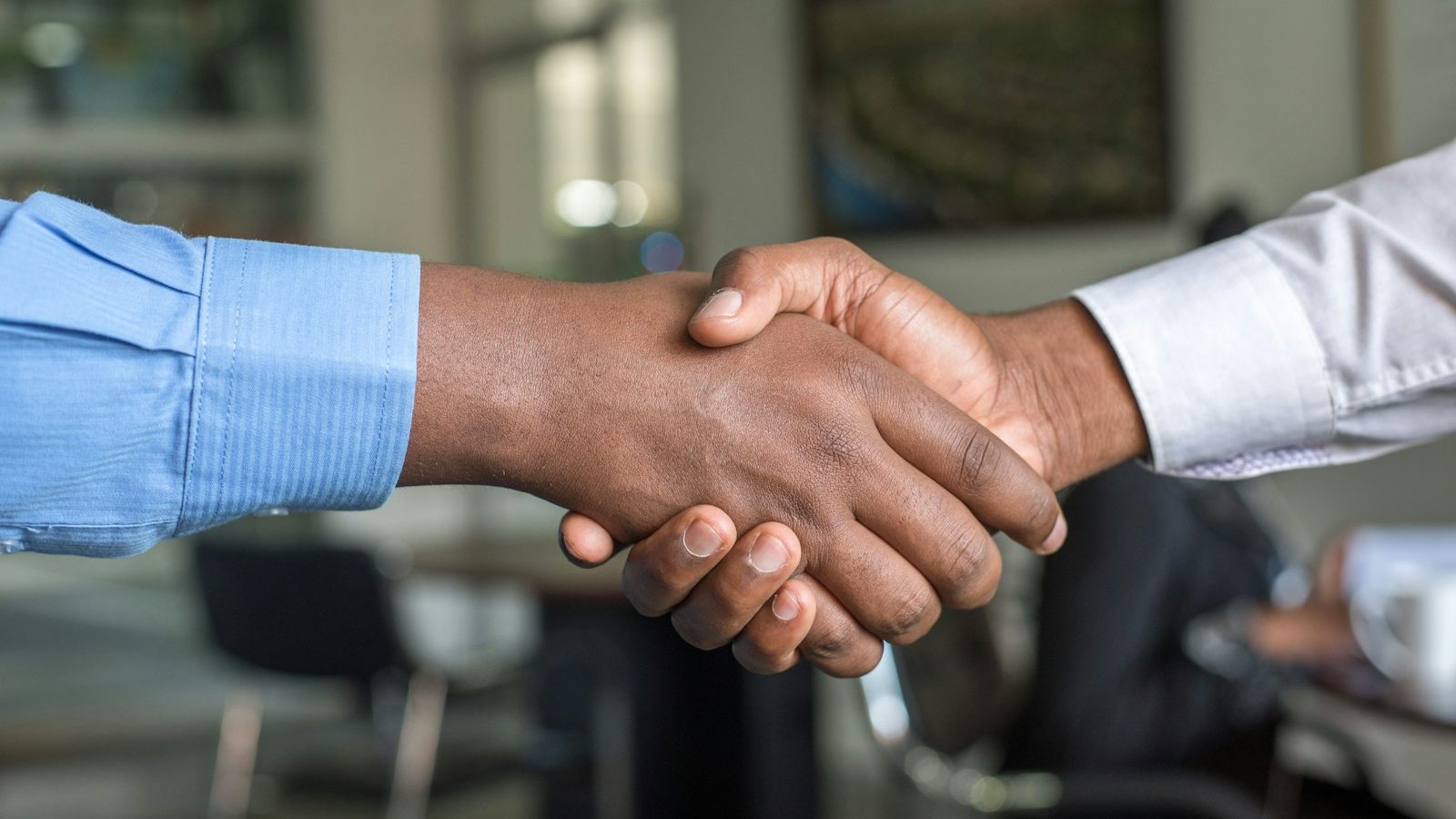 A restaurant owner shaking hands with a marketing consultant