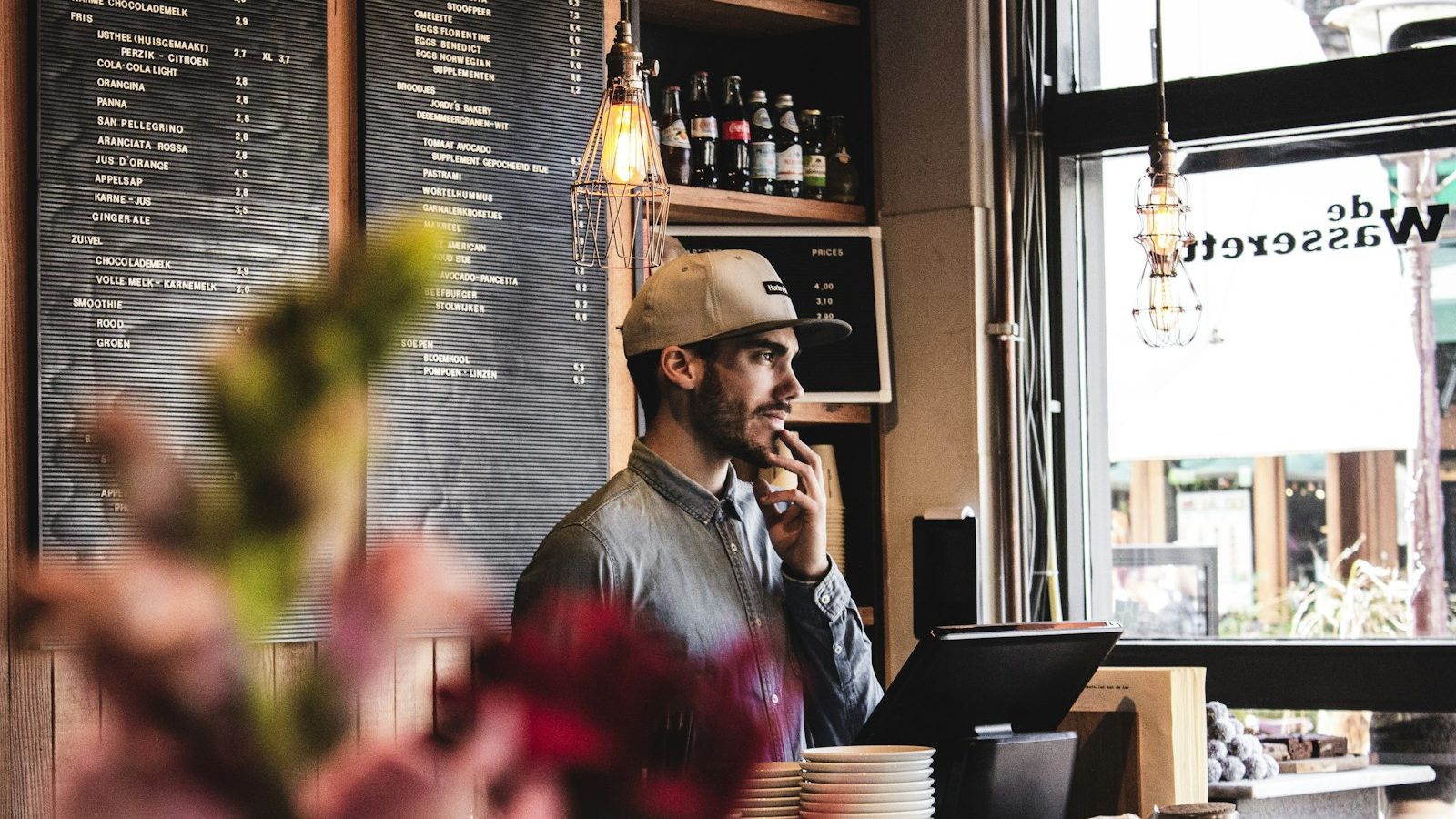 A restaurant owner holding a phone that shows their business listing on a map