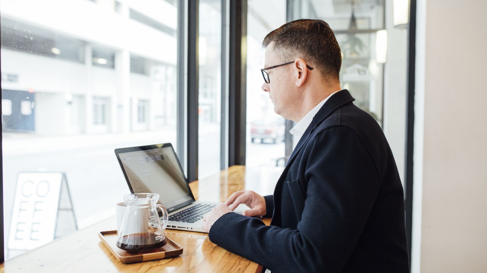 A person researching Google Ads on a laptop in a cafe
