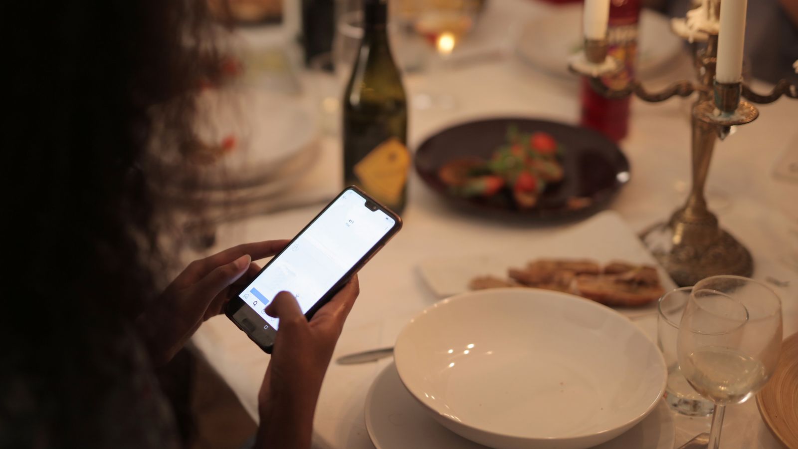 A diner booking a restaurant table from a phone at dinner