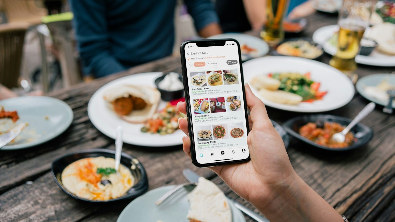 A restaurant owner reading a review on their phone at a table