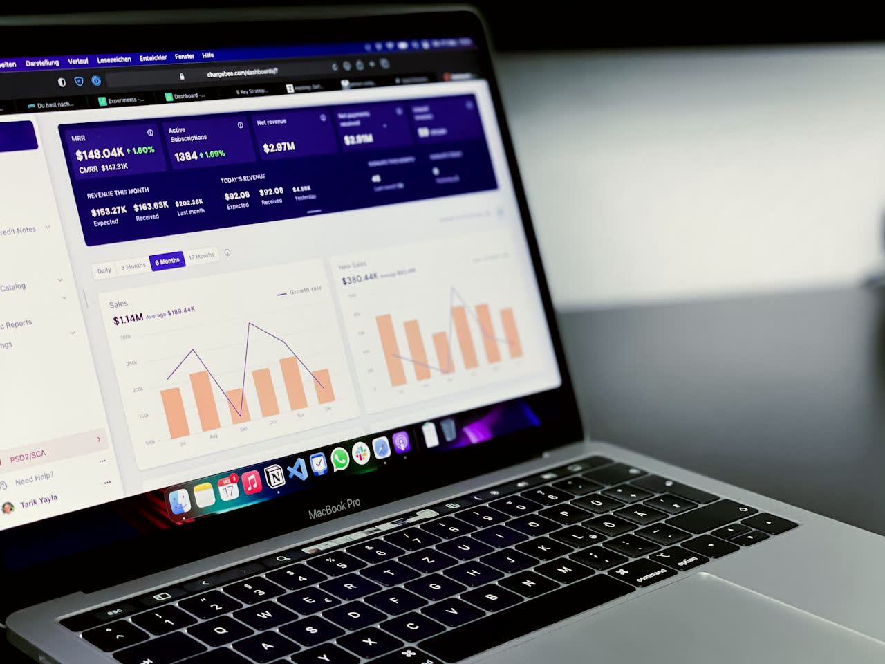 A laptop showing an analytics dashboard with revenue, conversions, and growth charts