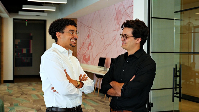 Two Button Up Media team members talking and laughing in the office